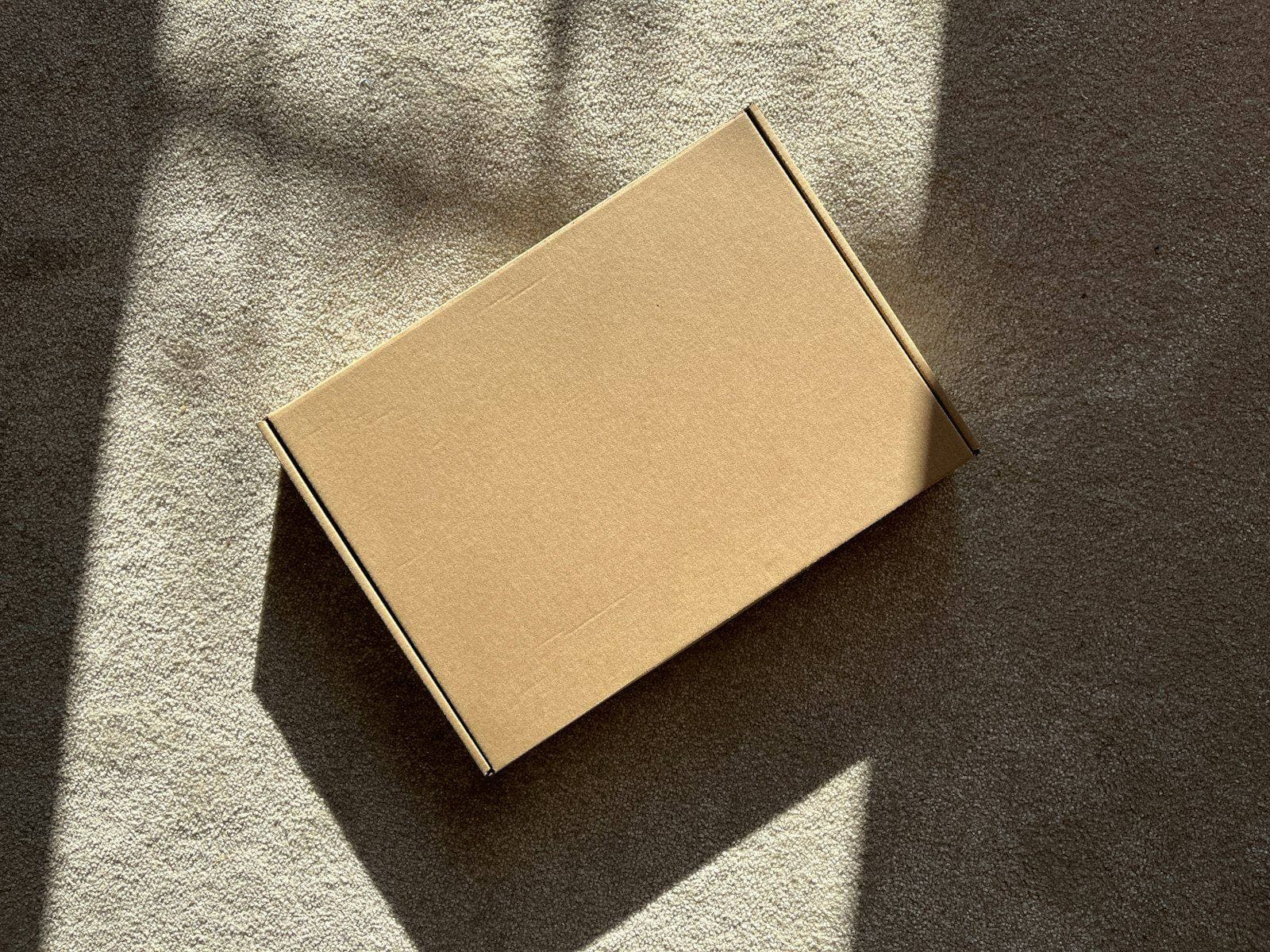 A cardboard parcel in a patch of sunlight, ready to go out